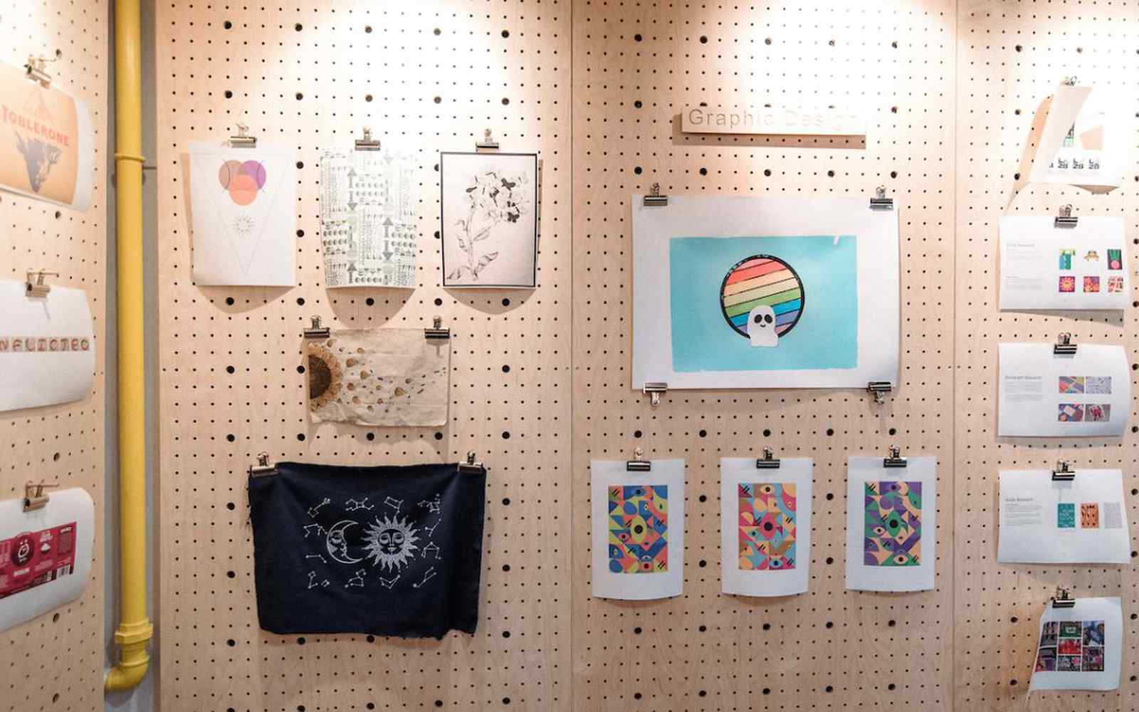 A peg board with artwork and products created by design students.