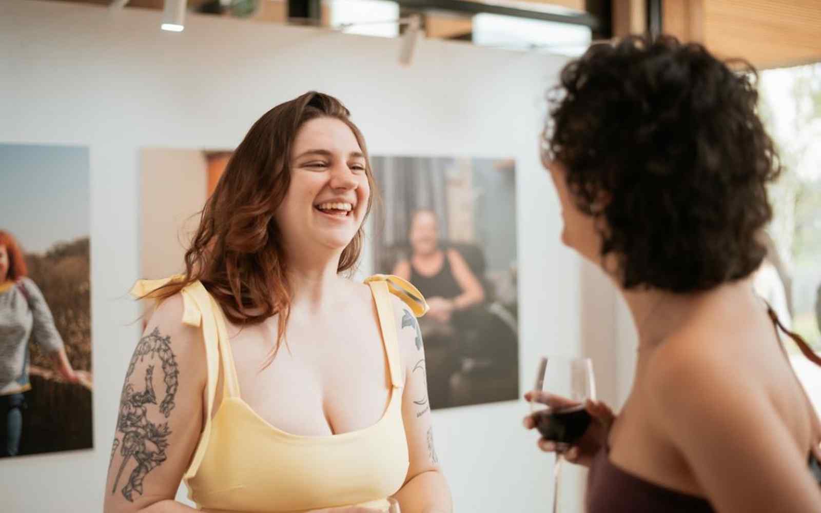 Two guests face each other and talk at the art exhibition.