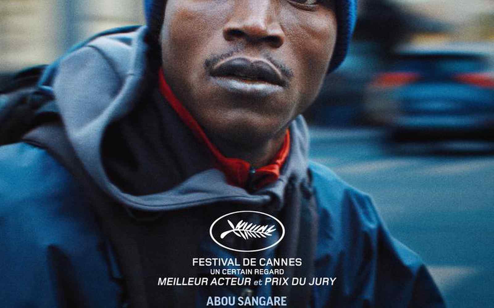 A male in a blue beanie hat with French text