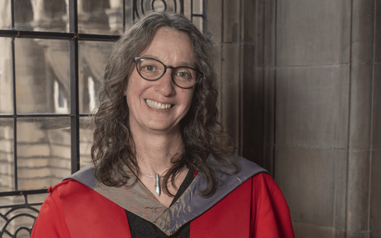 Head and shoulders image of a women looking directly at the camera with window in background