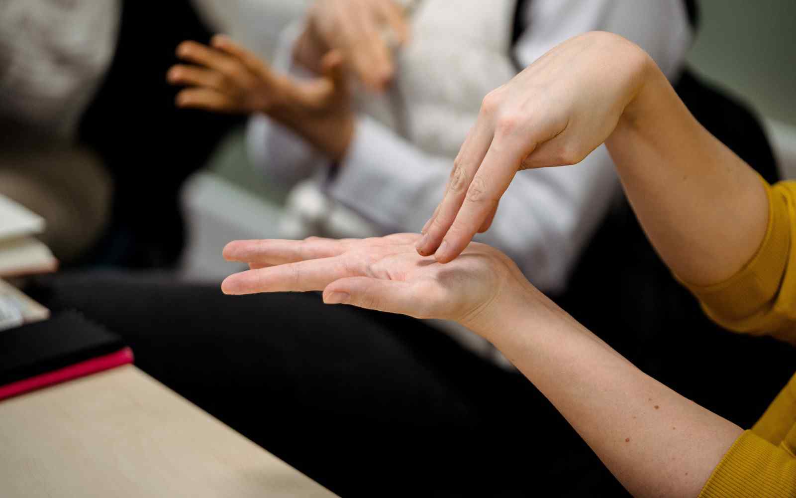 2 hands in a sign language pose with 1 hand above the other