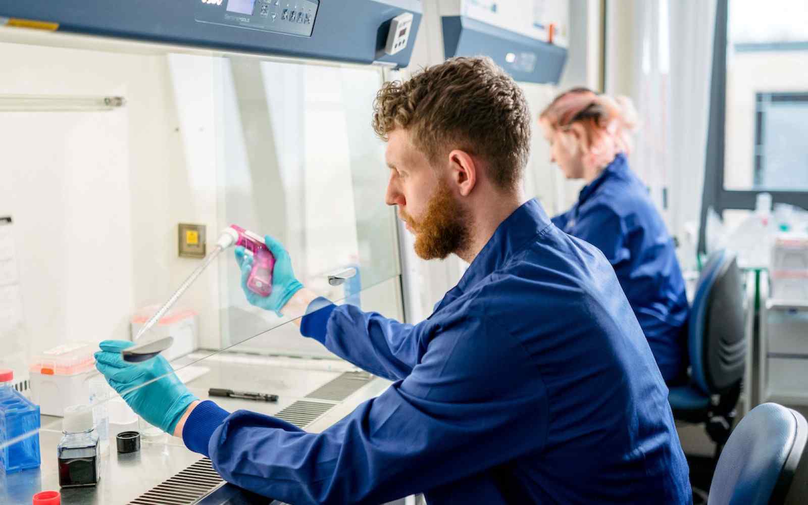 Two students working with chemicals in a lab