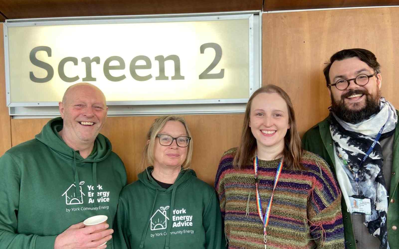 Four people in a cinema foyer next to a Screen 2 sign