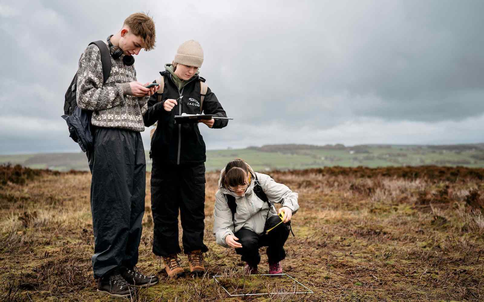 3 geography students conducting research on moorland