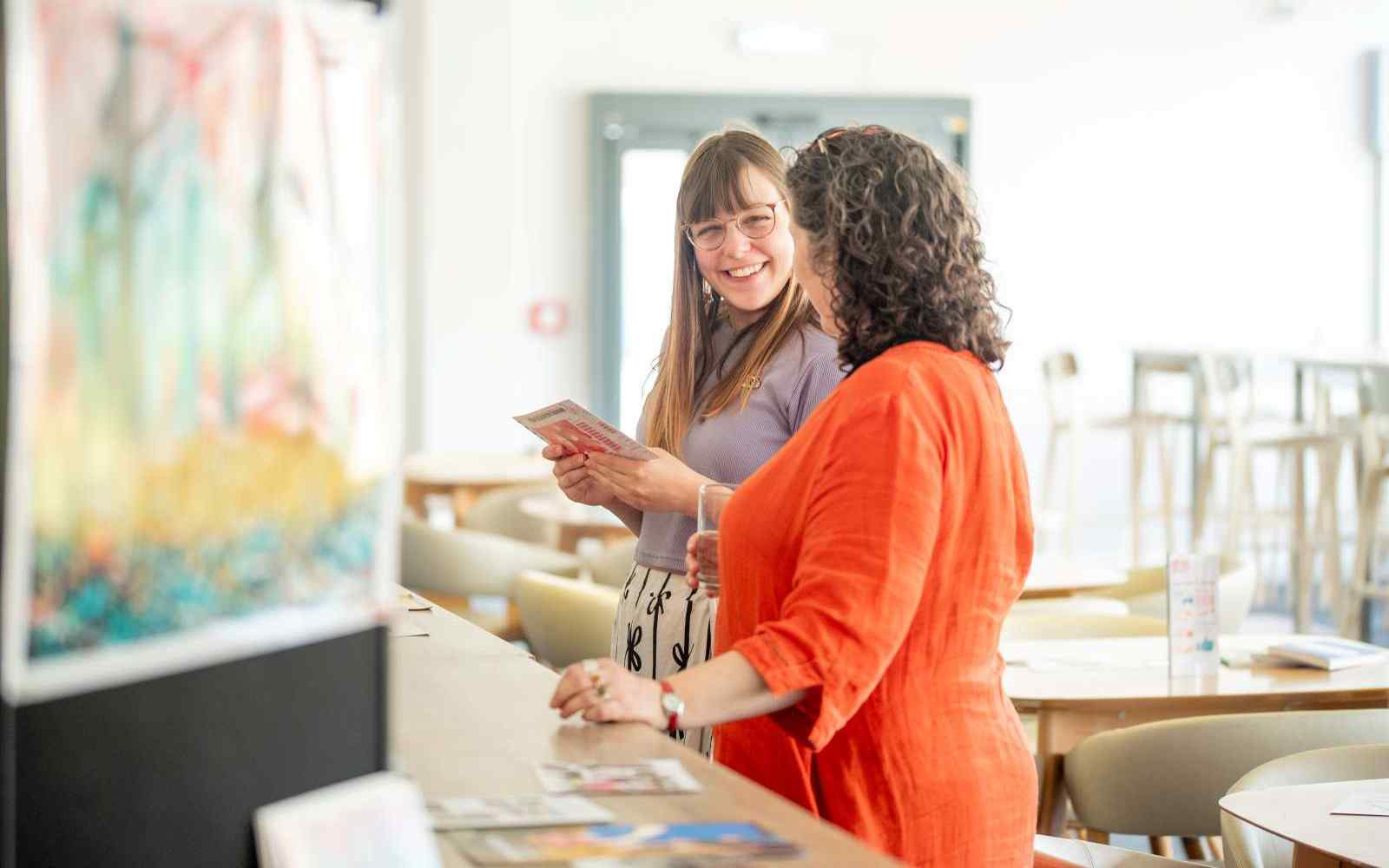 Two people talking and looking at artwork