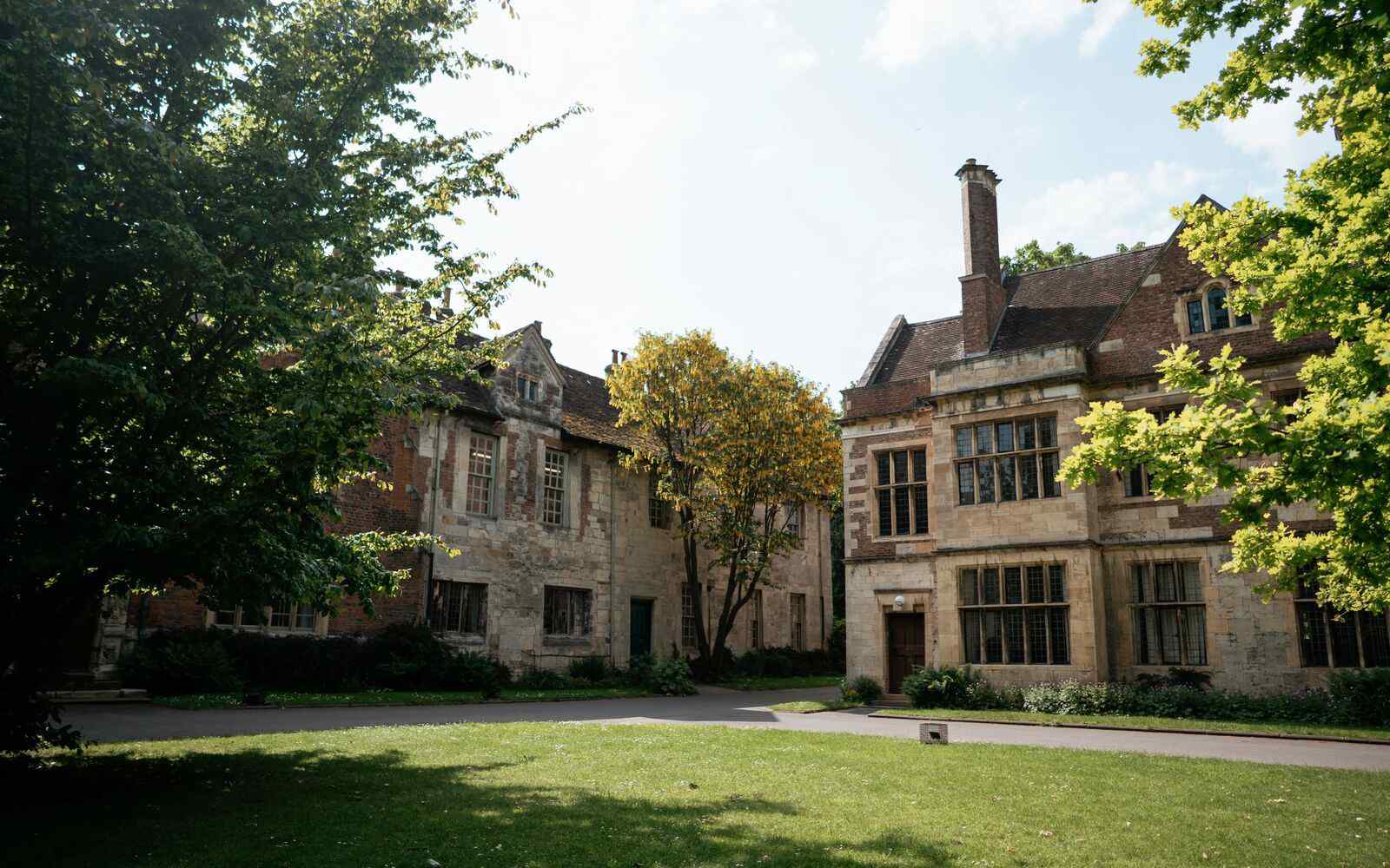 2 buildings with grass in front and trees to the left hand side