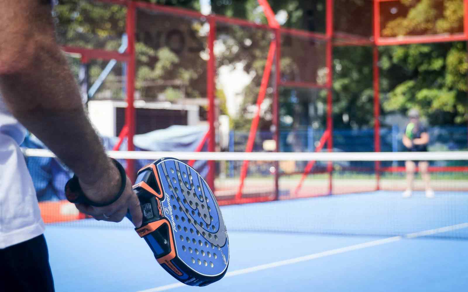 2 players face each other across the net on a padel court