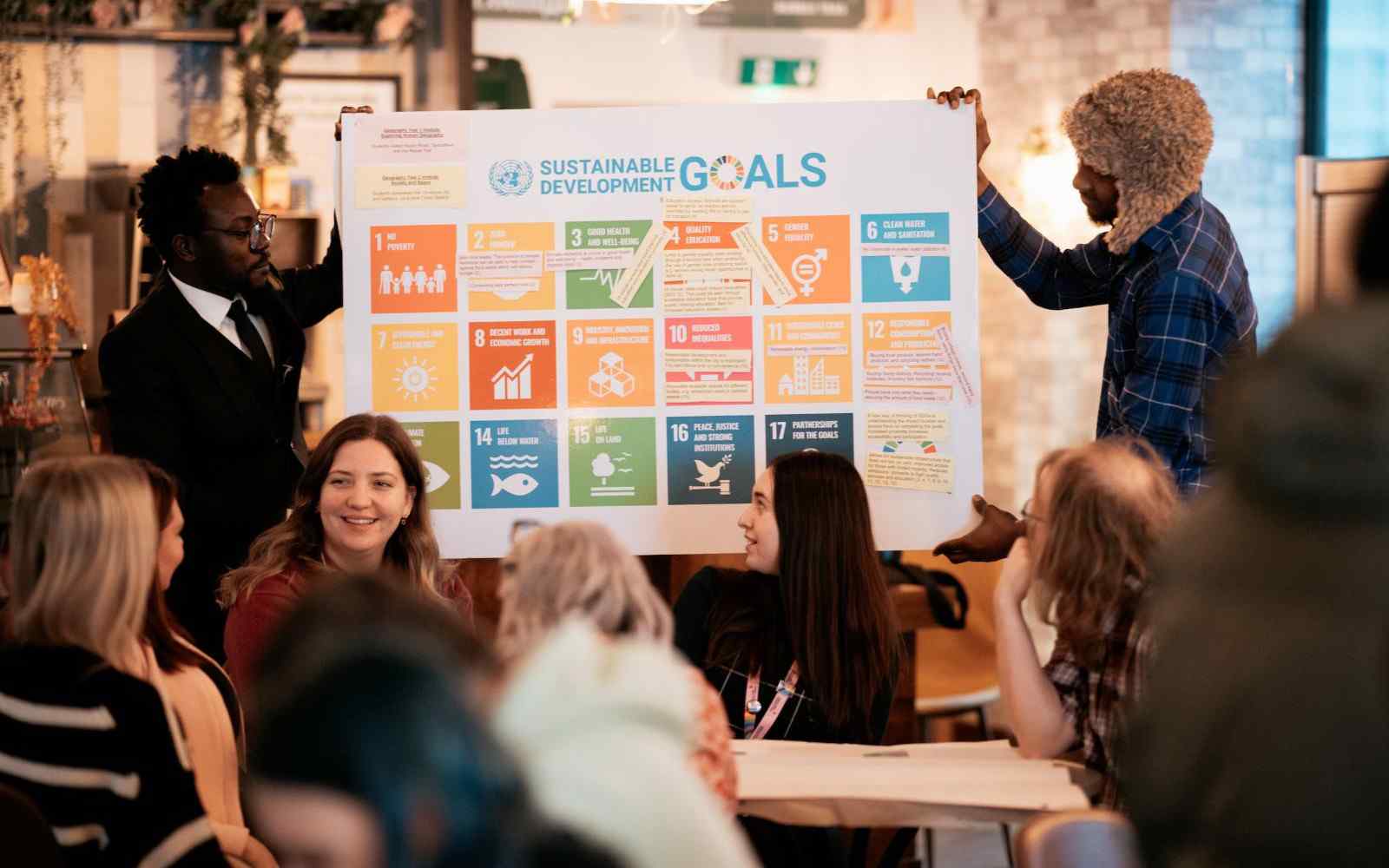 Two students doing a presentation about the UN sustainability goals to a seated crowd