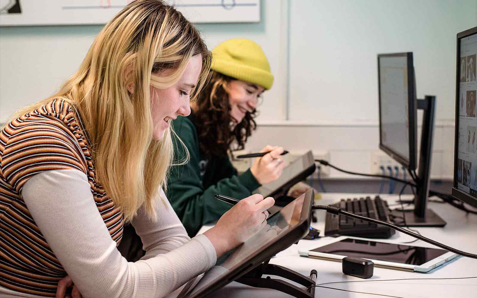 Two students working on tablets.