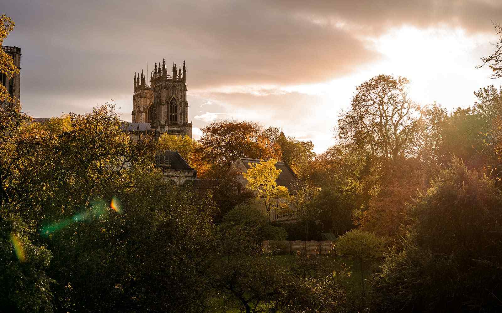 York skyline with sun shining over trees and Minster