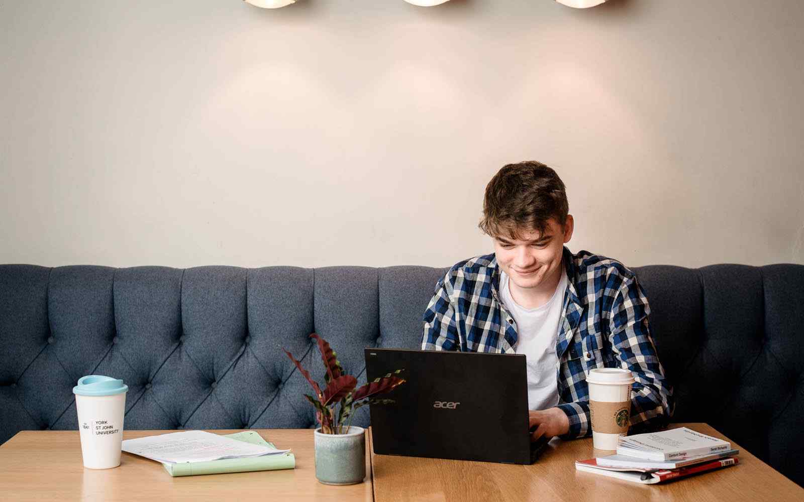 Student working at laptop in cafe