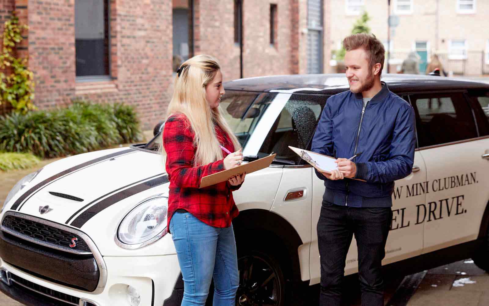 Students in conversation beside car