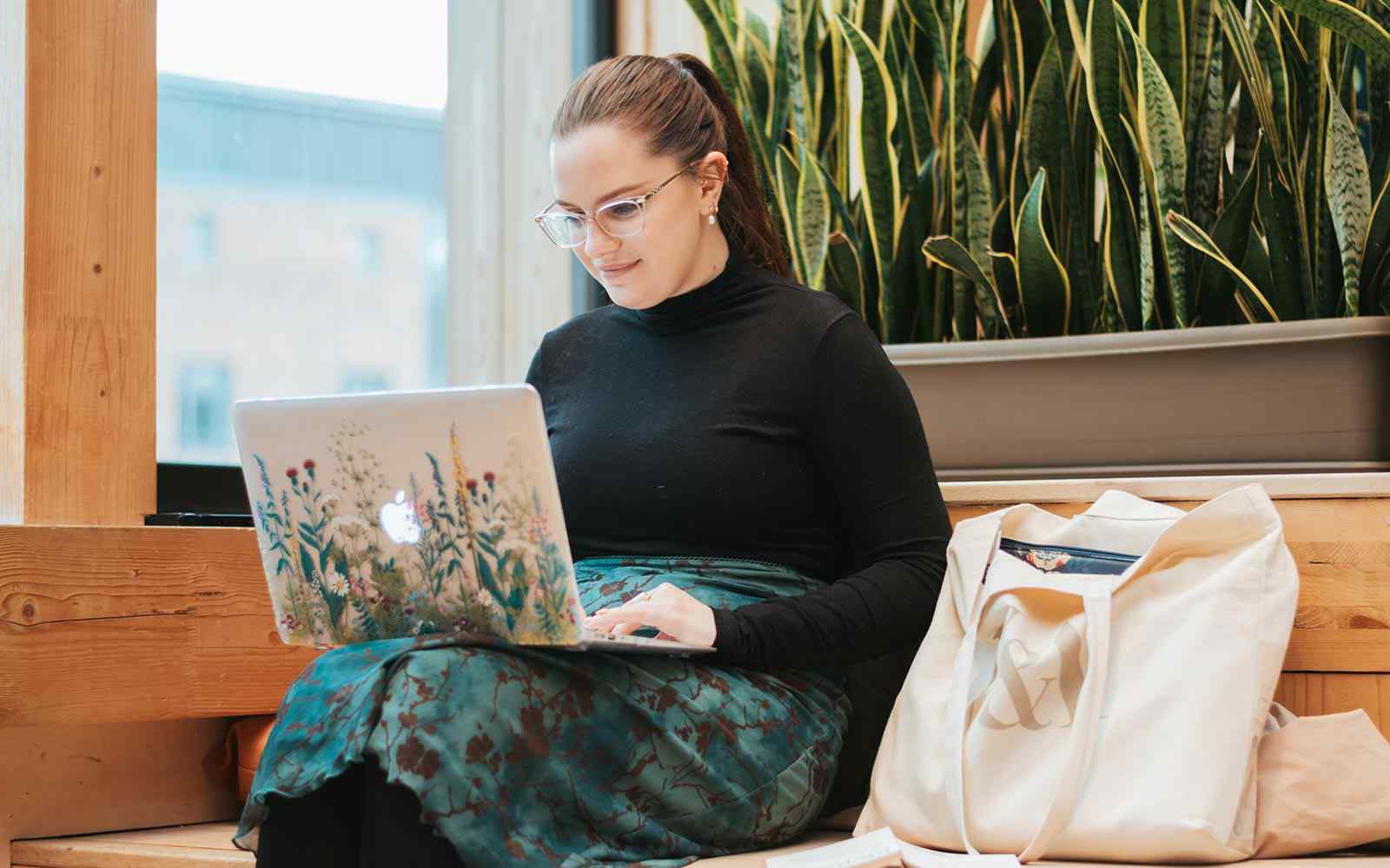 Student sitting on Creative Centre steps looking at laptop