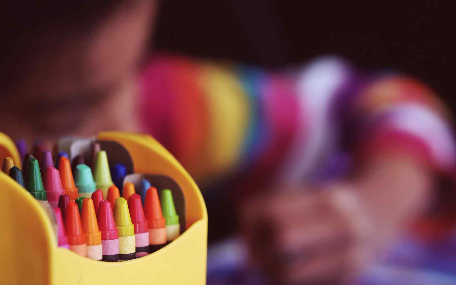 Close up of crayons in a classroom, while a child colours.