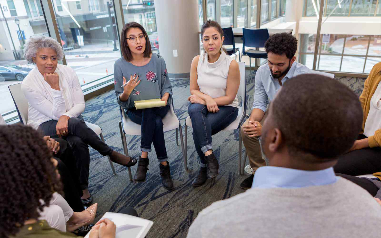 Adults sitting in a circle during a discussion.