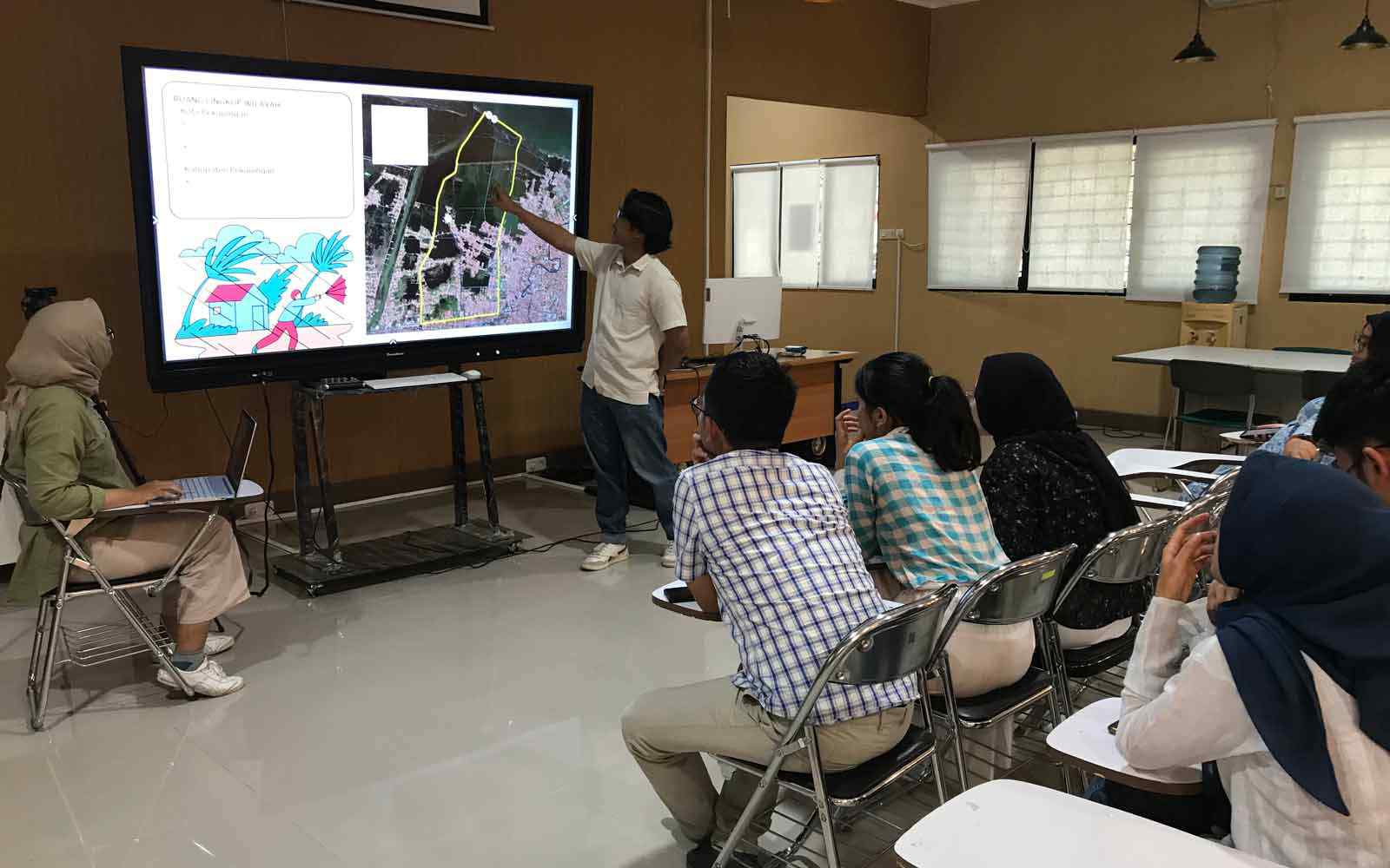 Student scientists in a classroom looking toward presentation on screen