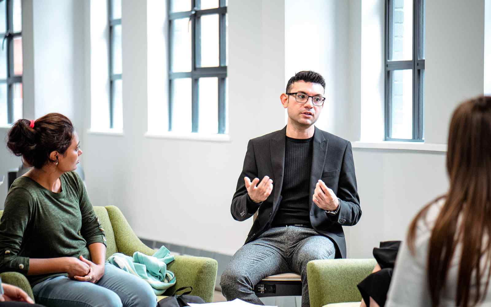 London campus tutor talking with students.