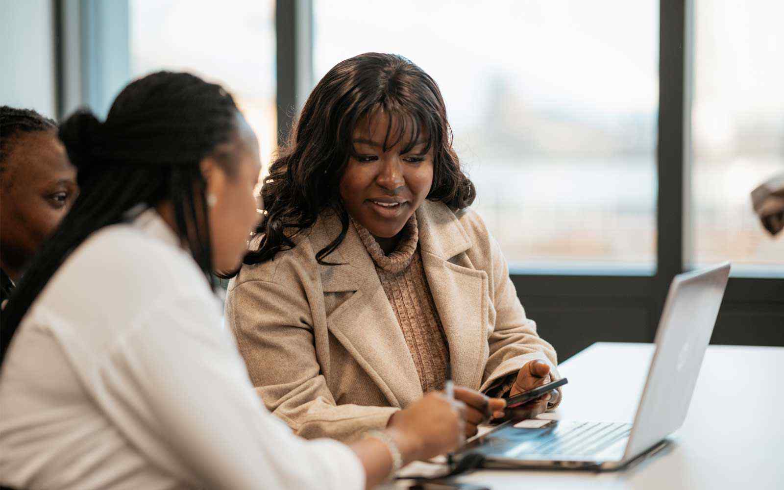 A staff member and student looking at a laptop at York St John London campus.