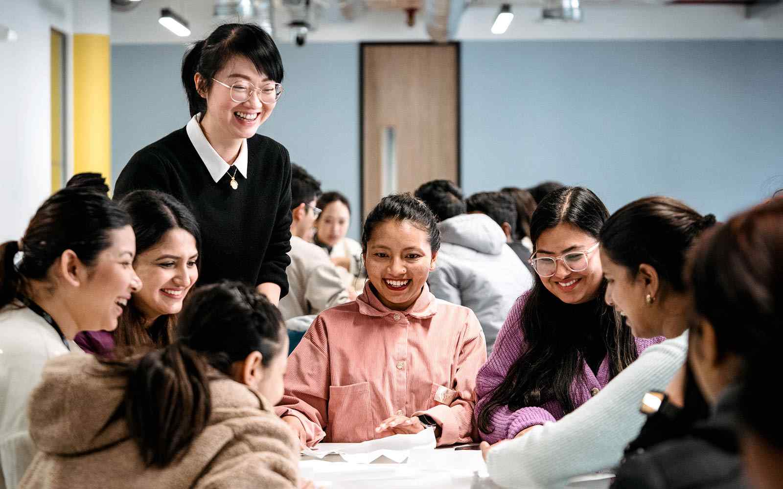 Lecturer laughing with group of students