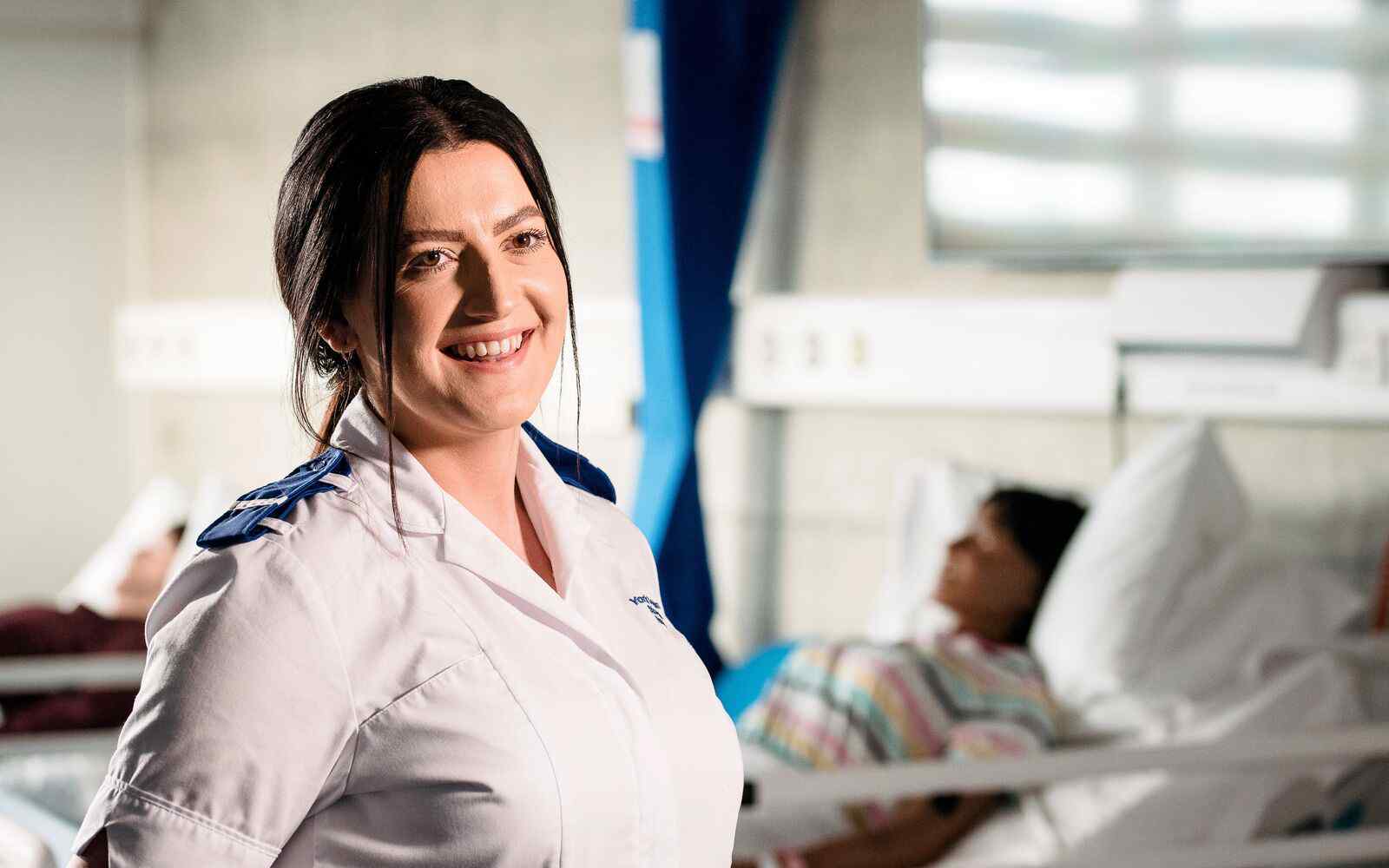 Student nurse in front of a ward
