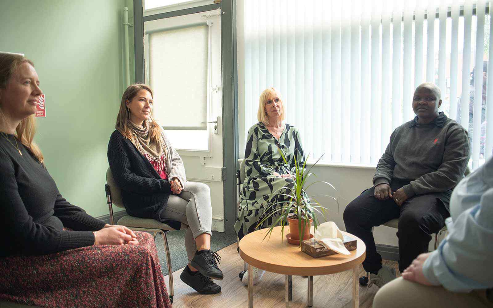Four people sat around a coffee table having a discussion