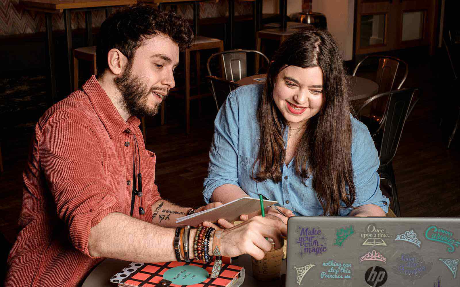 Two students looking at a laptop in the SU bar