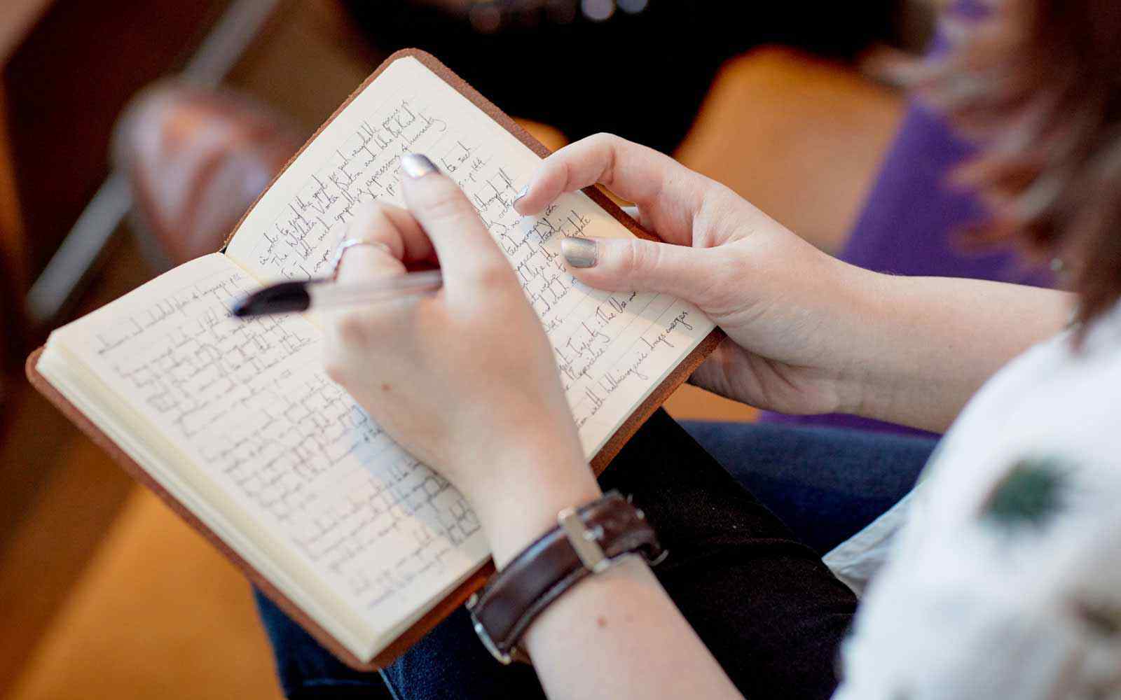 A student writes in a notebook.