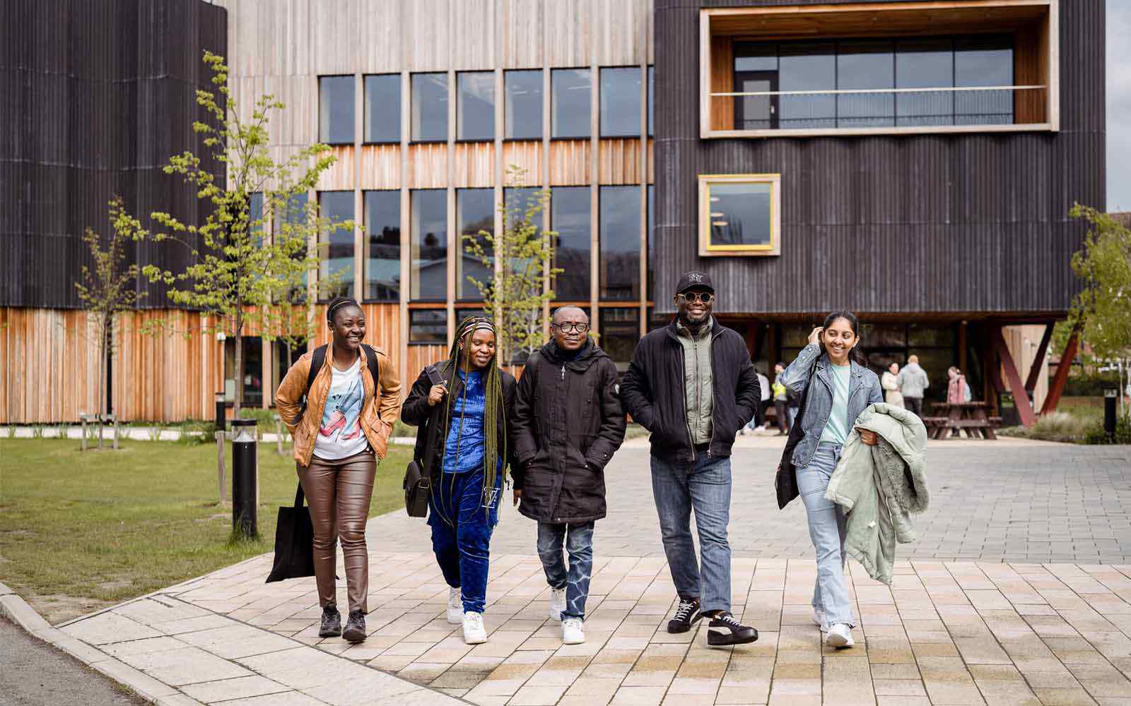Five students walking together outside the Creative Centre on campus.