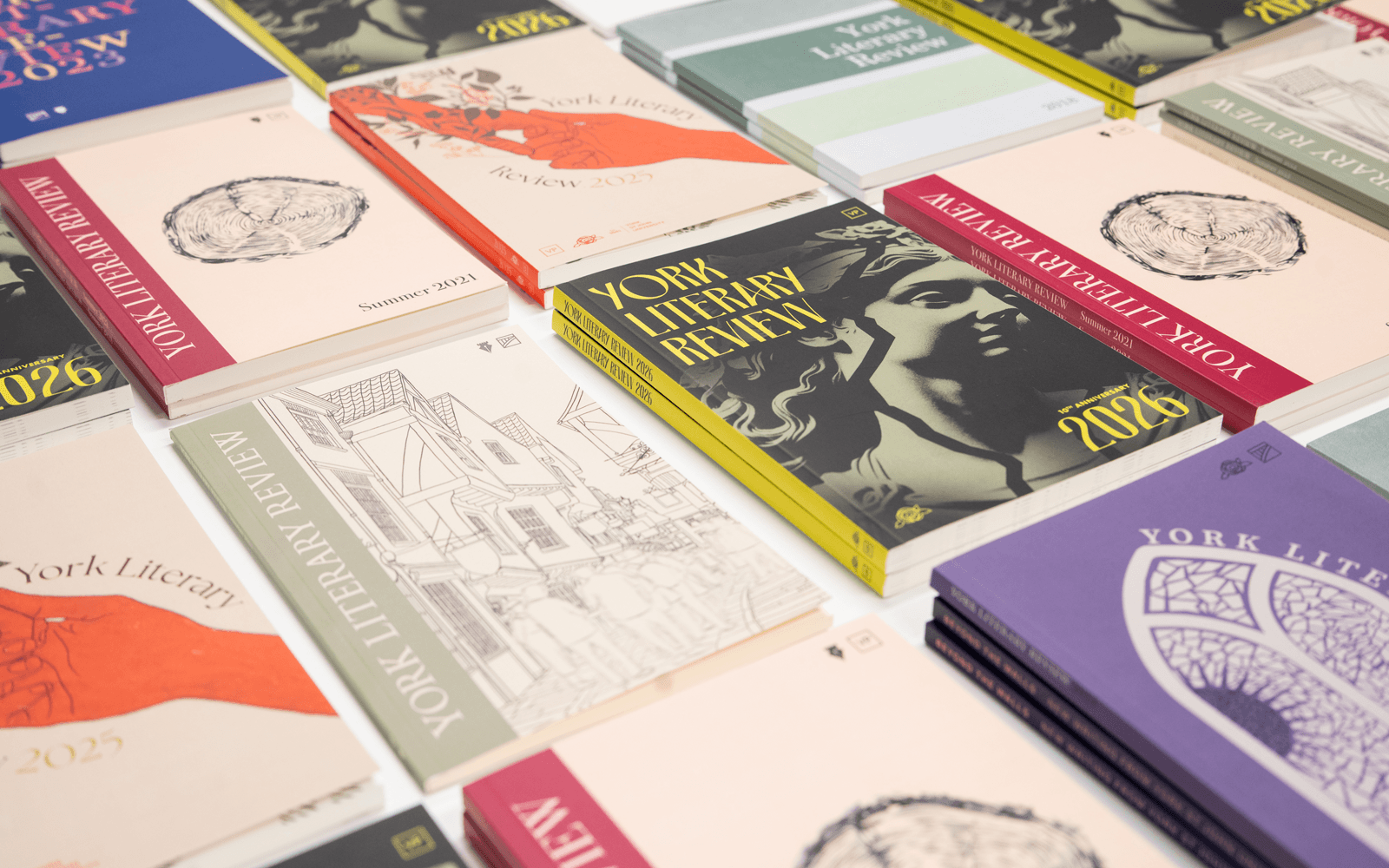 Different yearly editions of the York literary review displayed in an artistic grid format on a table