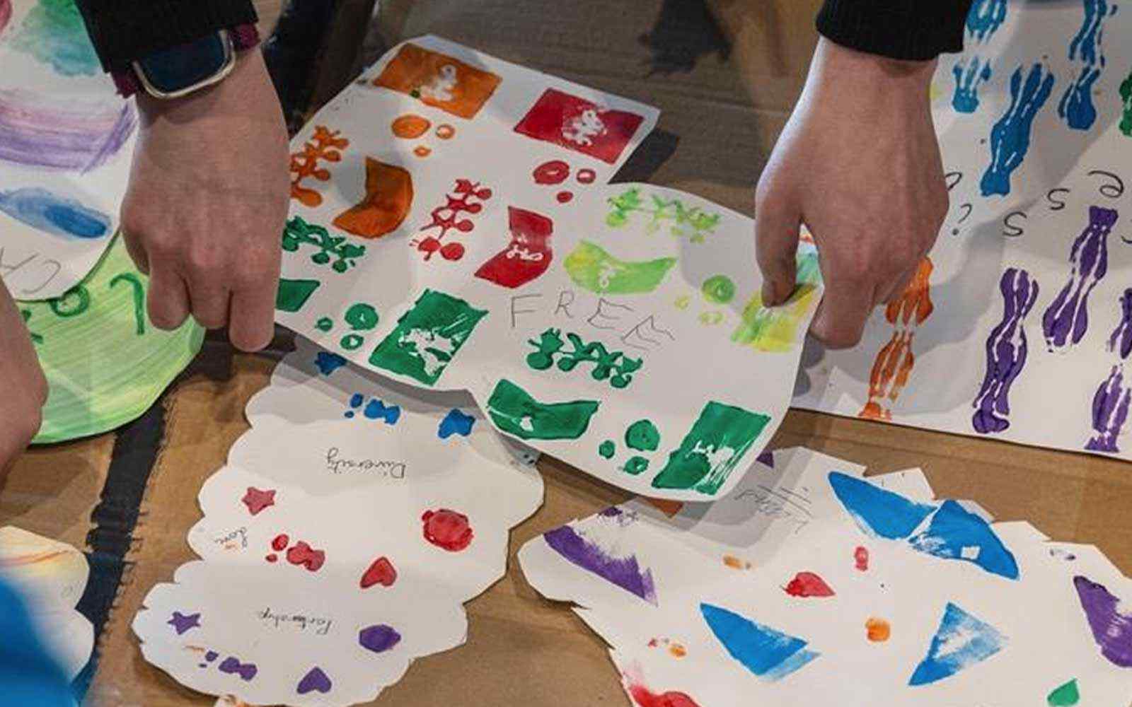 An image showing hands doing finger painting on paper