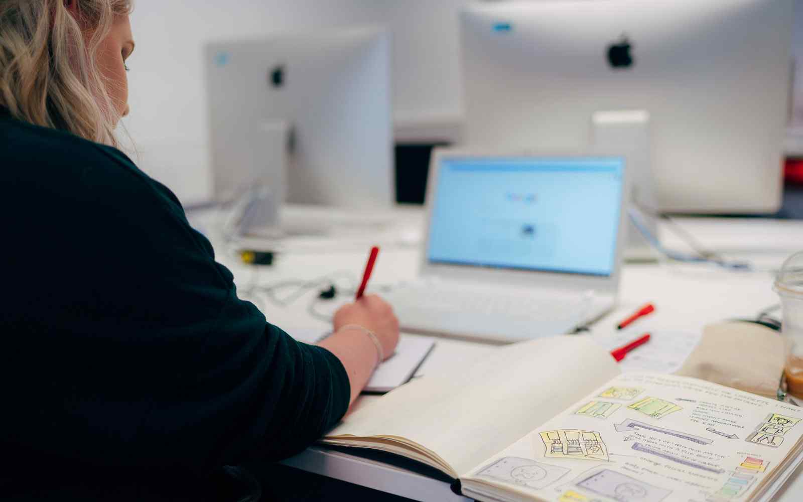 A student studying with a laptop and notebook.