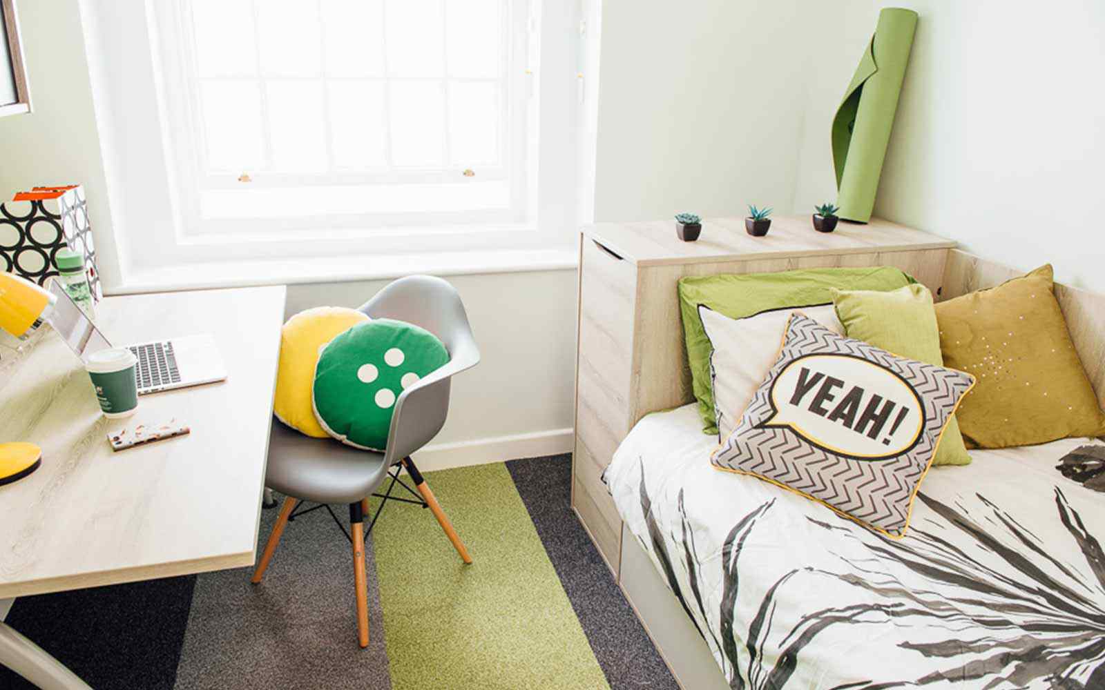 Room in The Grange accommodation, with single bed, desk and chair, and storage.