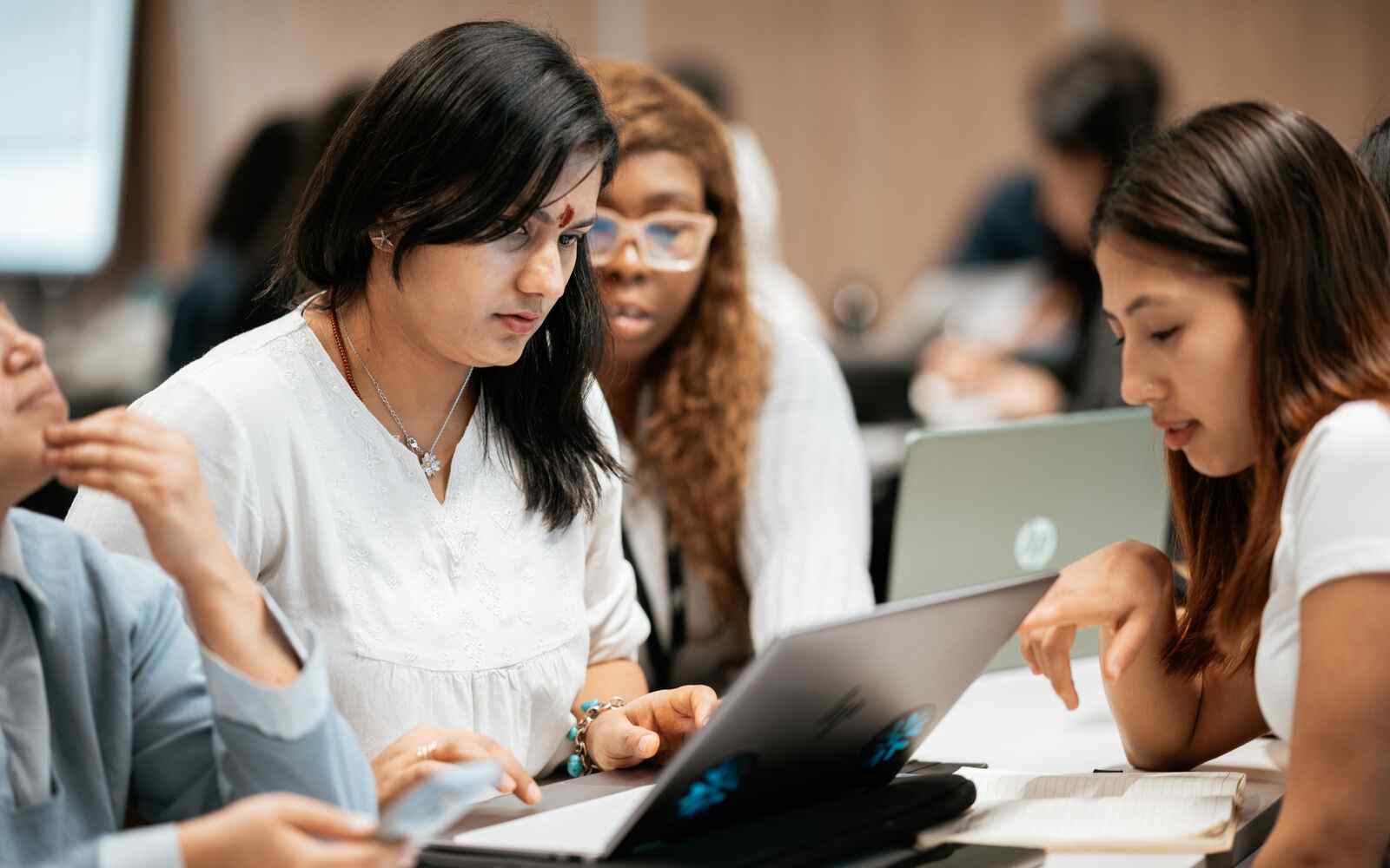 A group of students looking at a laptop together