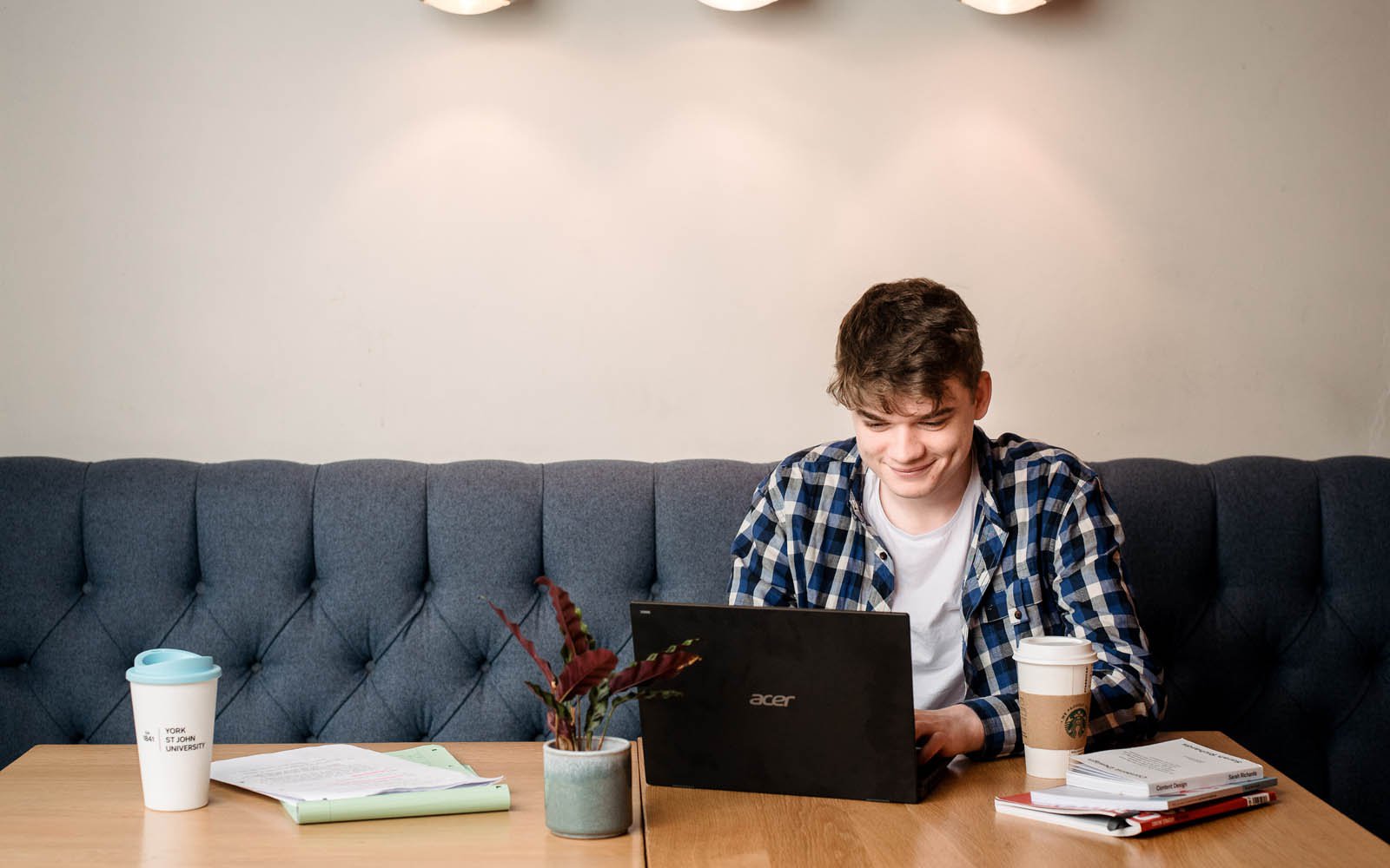 Student working at laptop in cafe