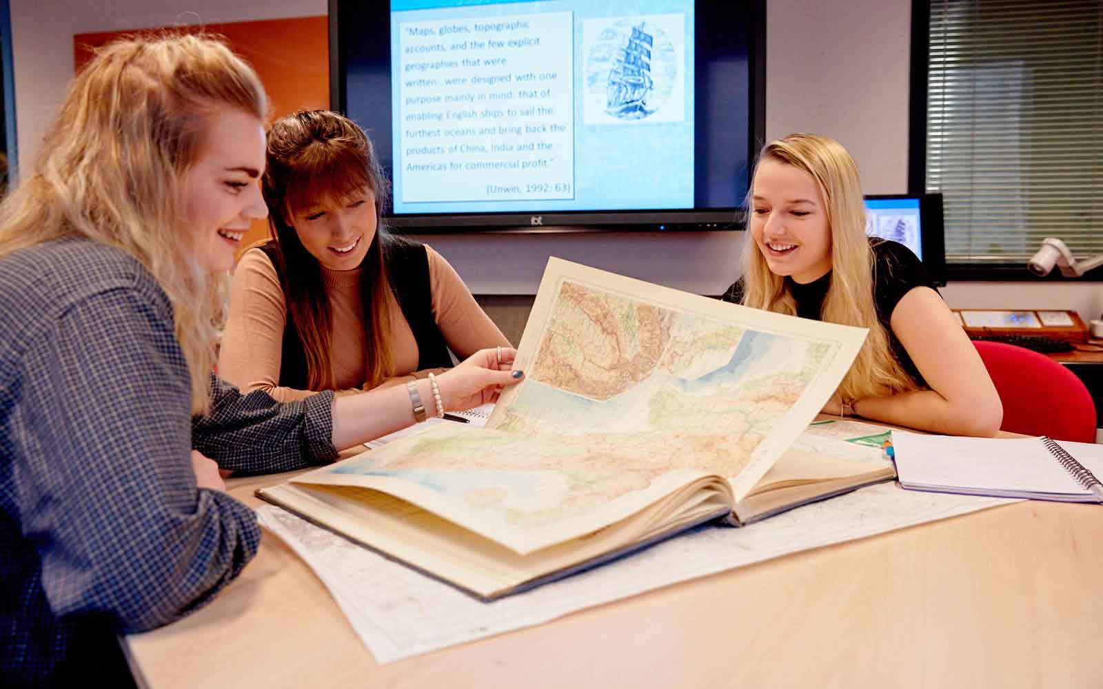 Students looking at map book