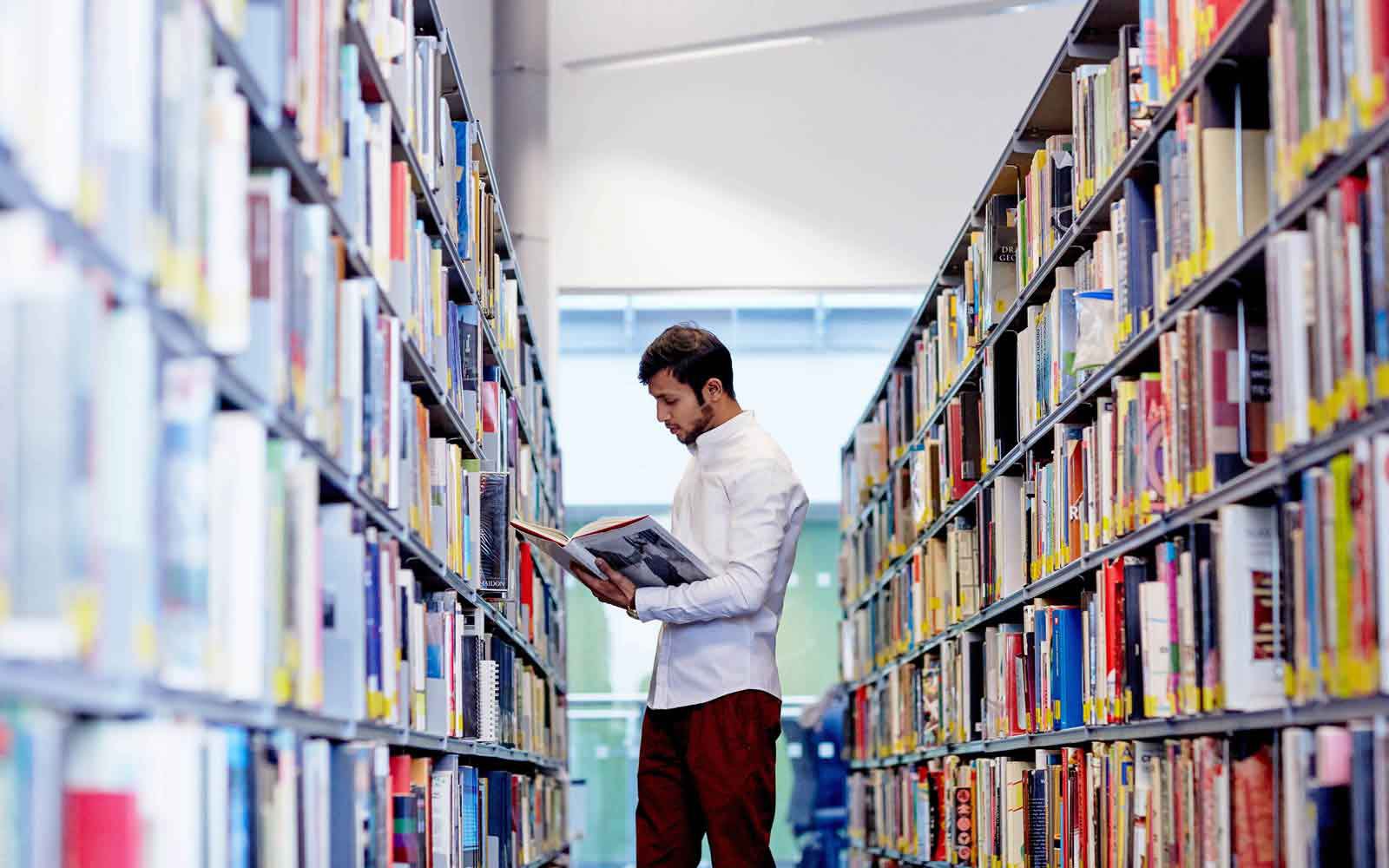 Student between shelves in library