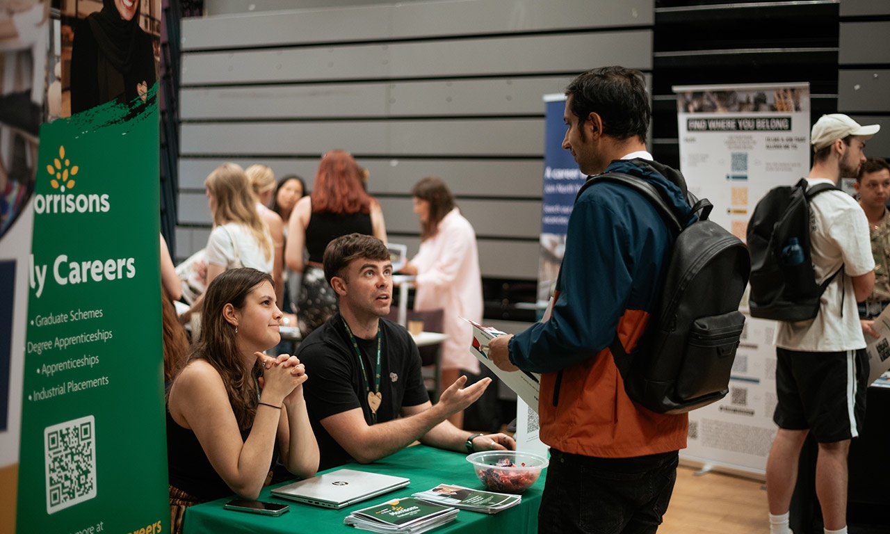 Student talking to representatives at Morrisons stall at Graduate Careers Fair 