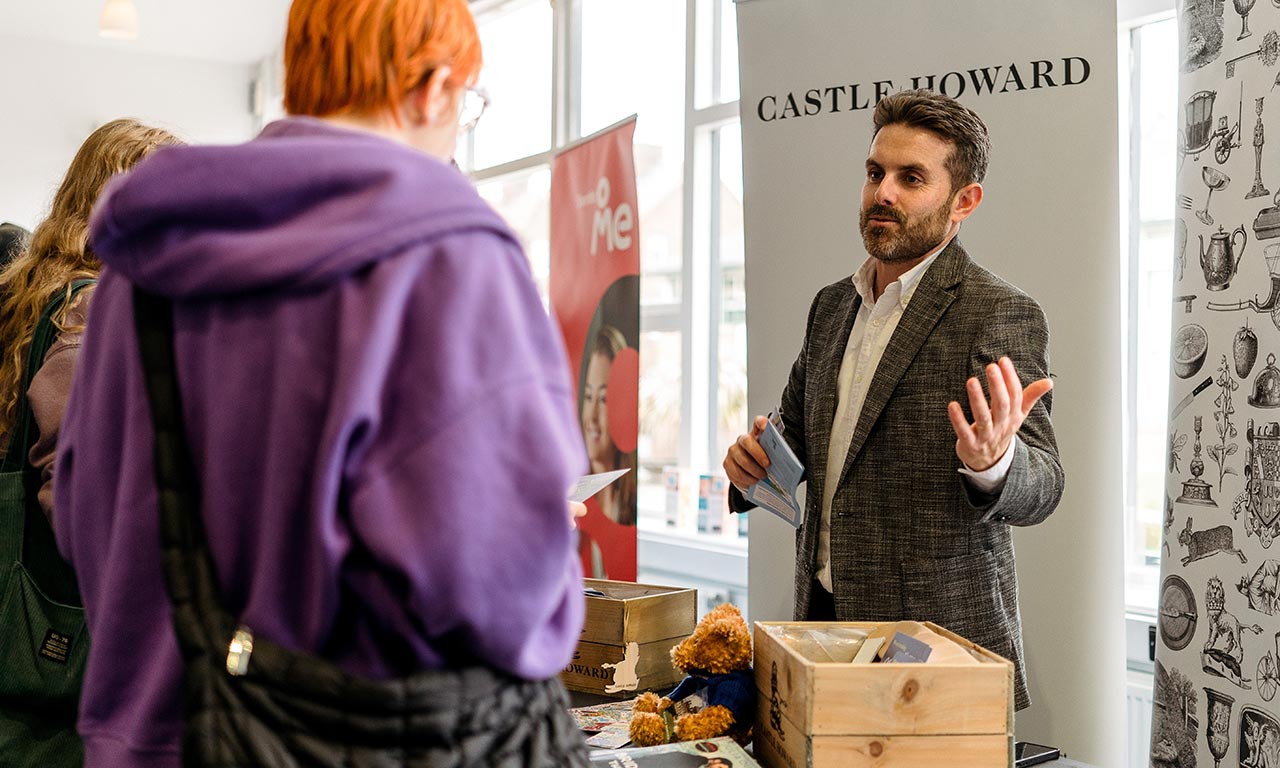 Representative from Castle Howard talking to student at stand at Jobs Fair 