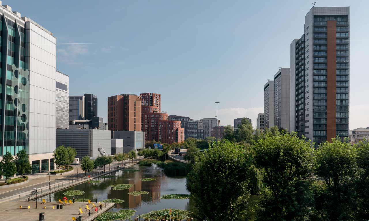 Green space and lake with tall buildings, near London Campus. 