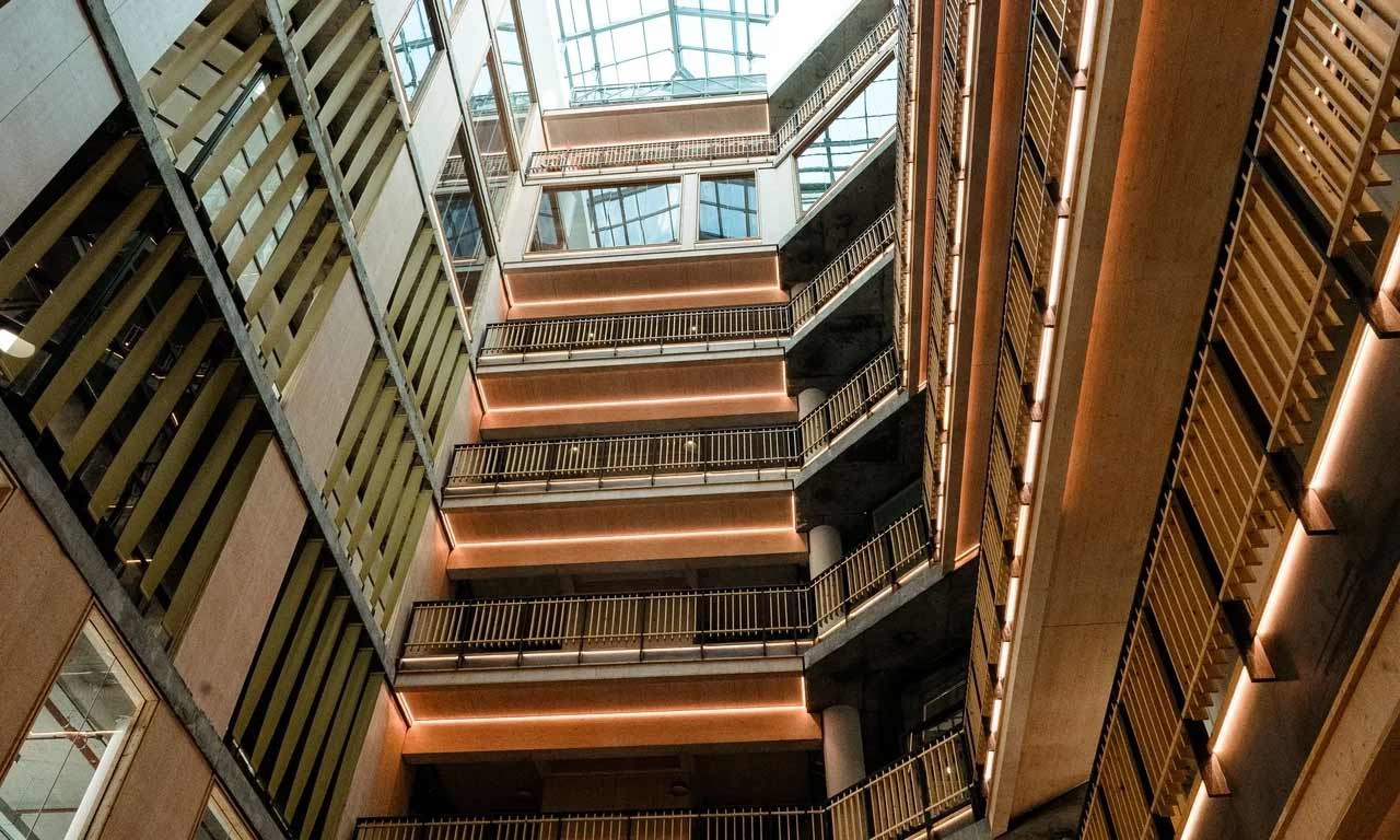 Interior of YSJ London Campus, looking up through atrium. 