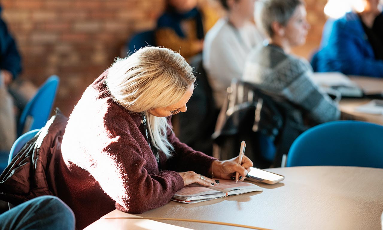 Delegate taking notes at Teacher and Adviser Conference 