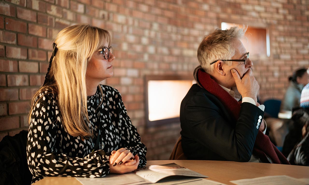 Two delegates sat at table at Teacher and Adviser Conference 