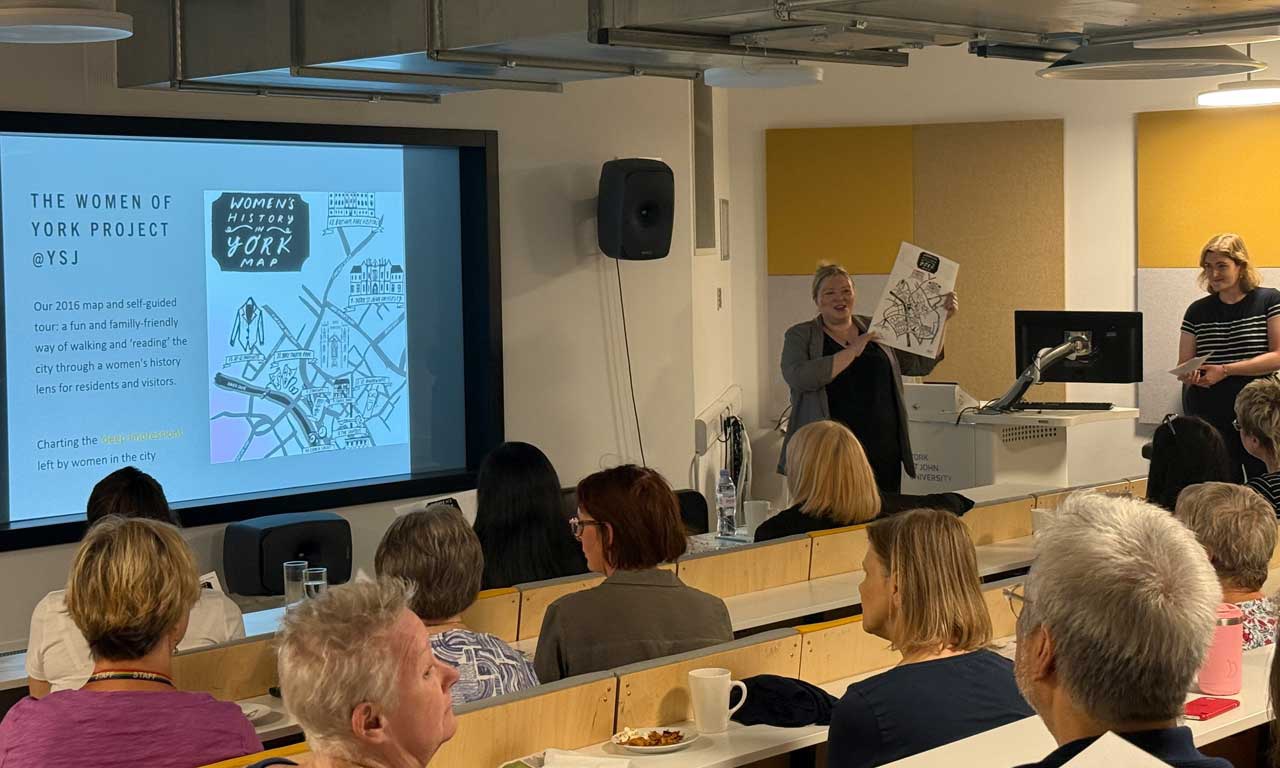 A presenter showing the Womens History in York map to an audience. 