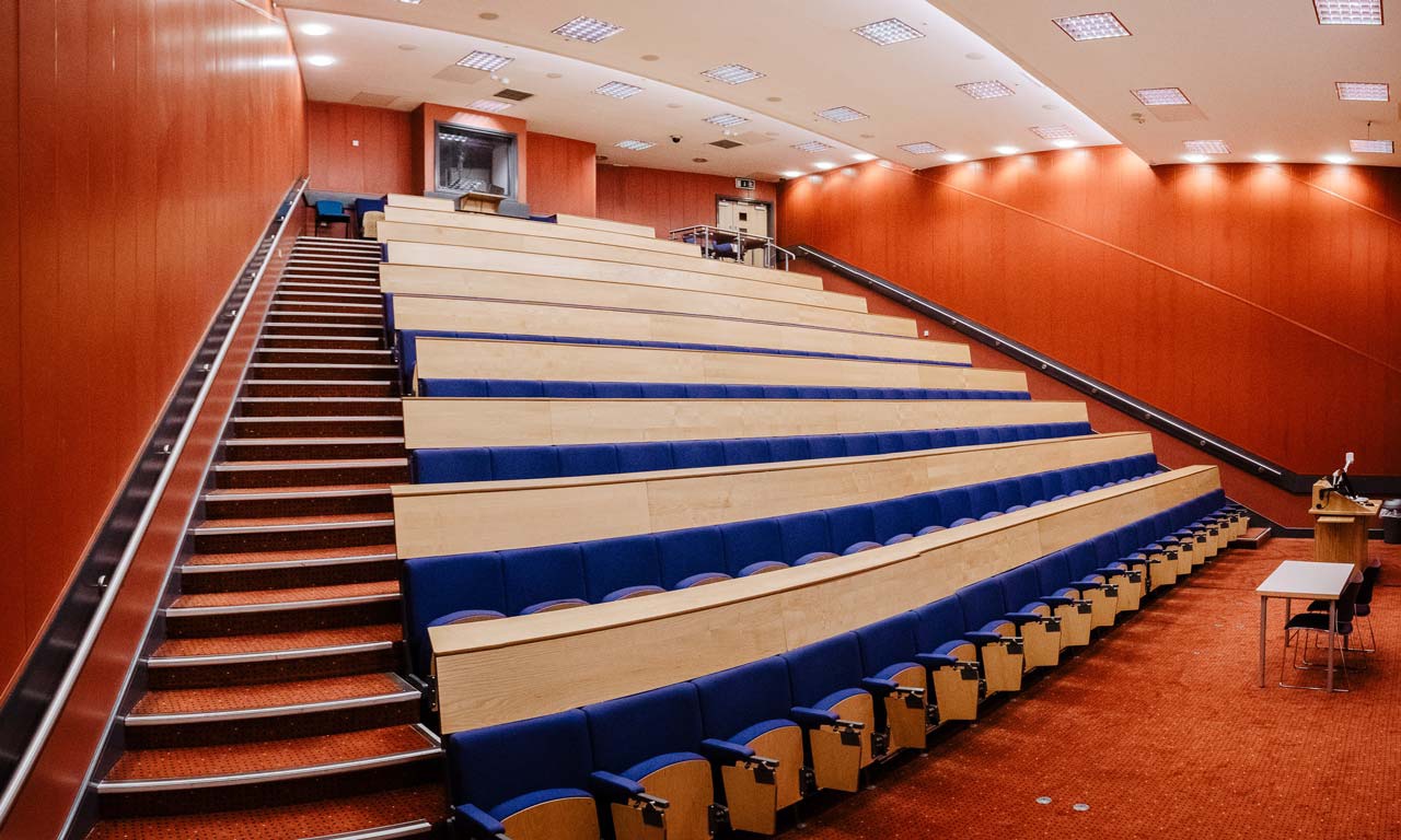 Lecture room with tiered rows of individual chairs and desks 