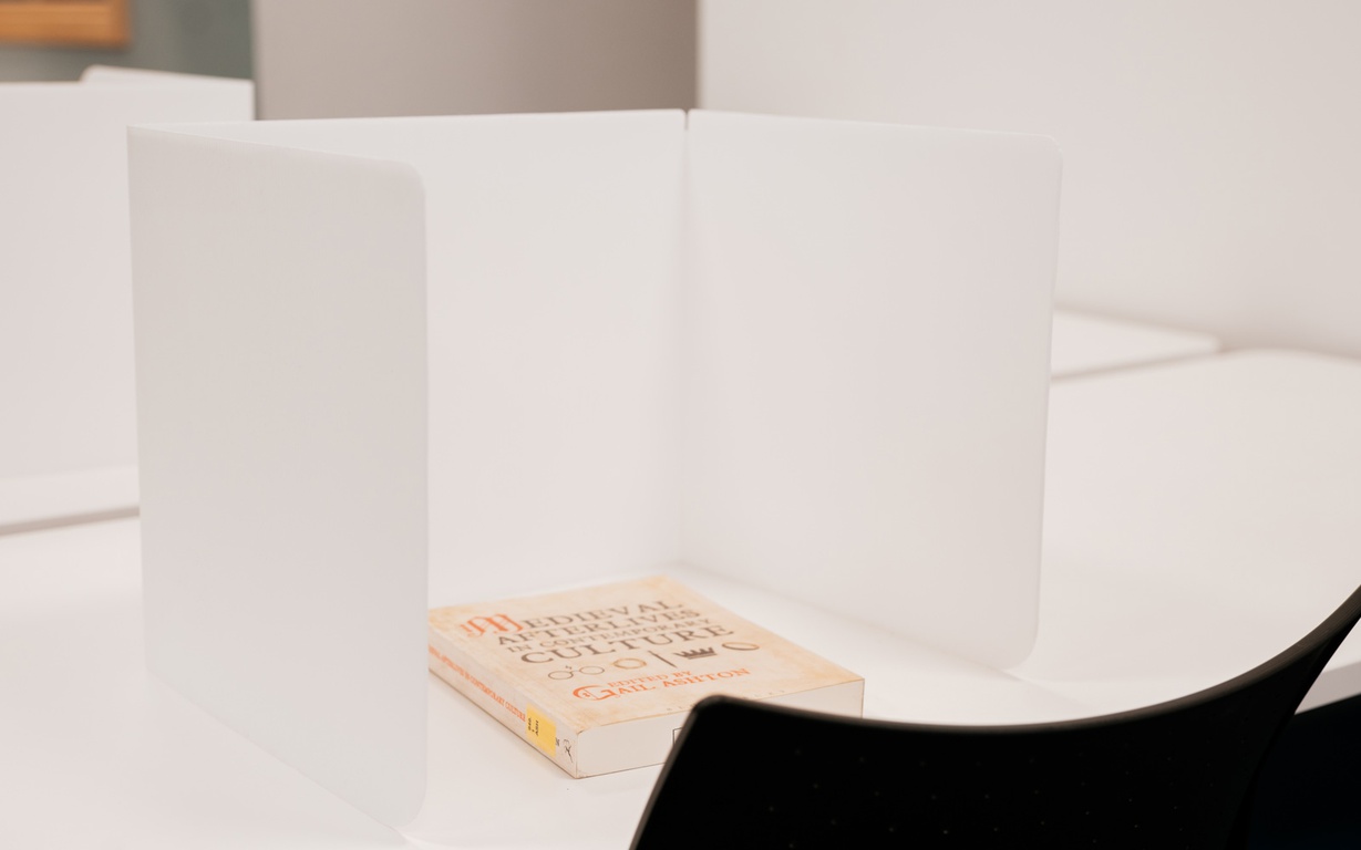A portable desk divider in use on a desk. 