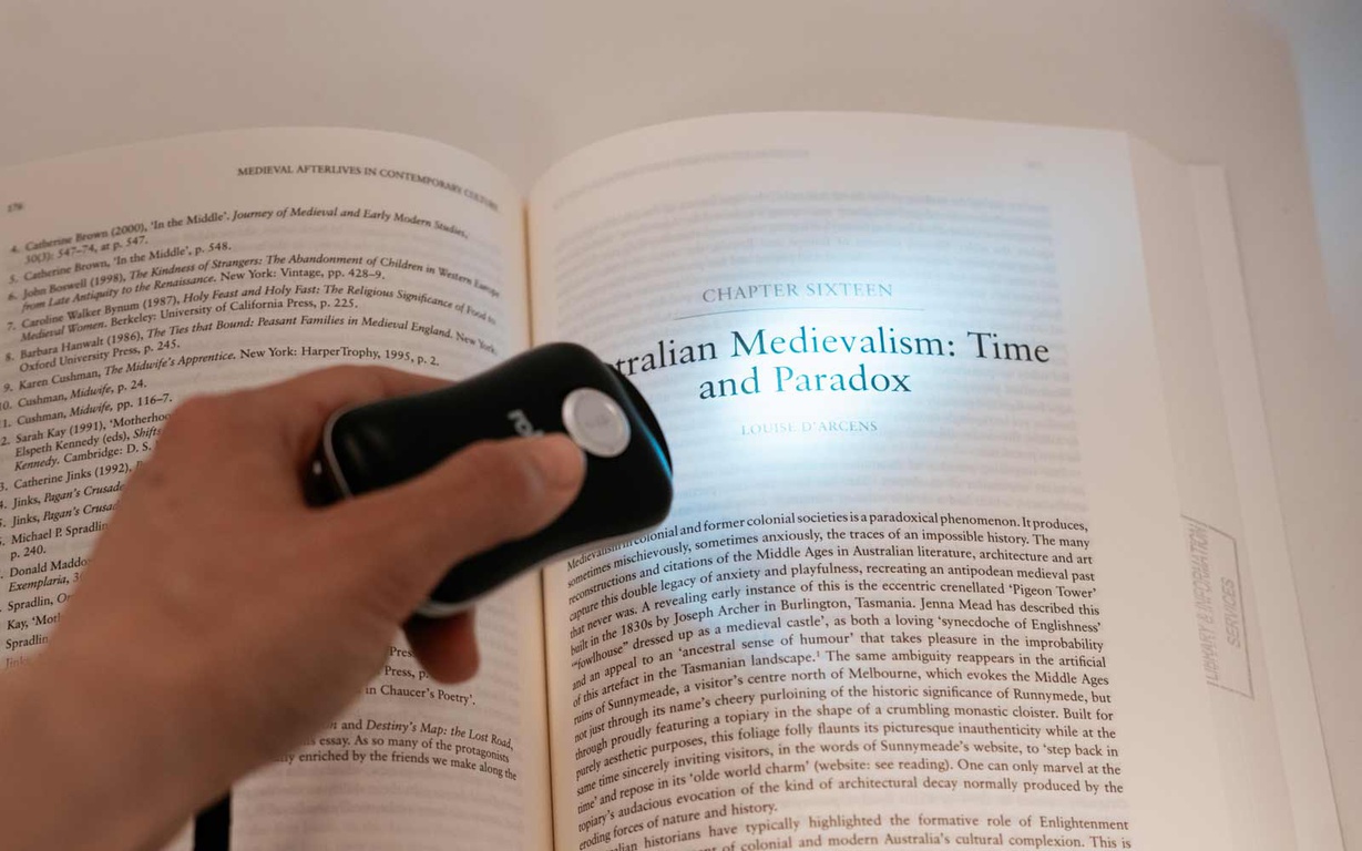 A torch being used to see text in a book. 