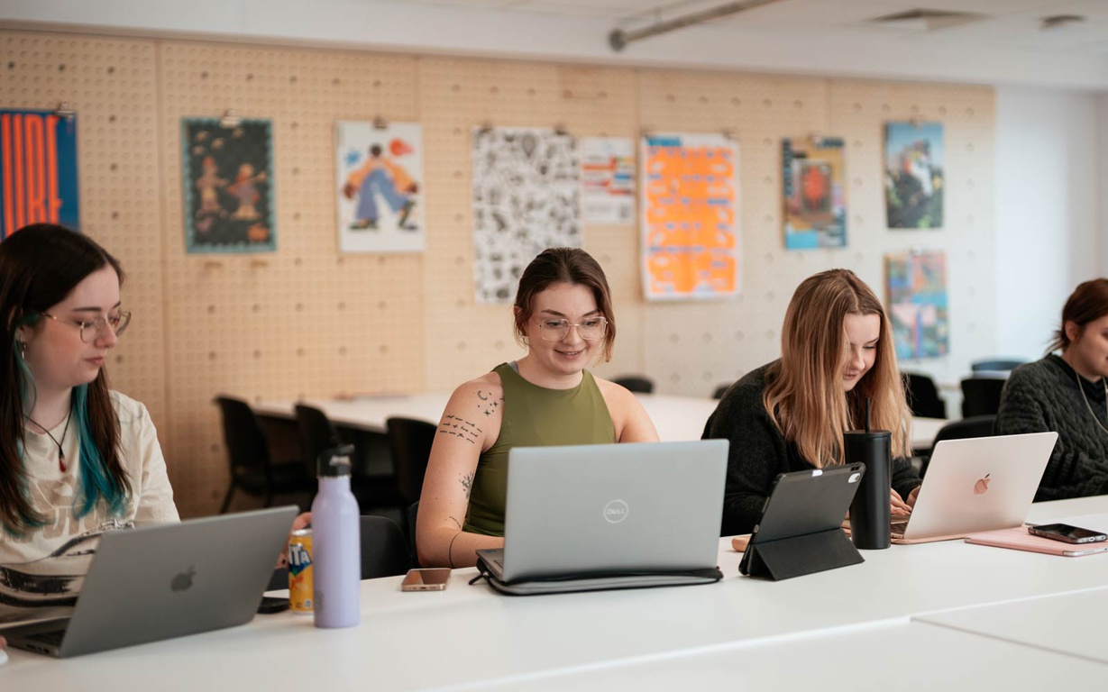 Students using laptops in a classroom. 