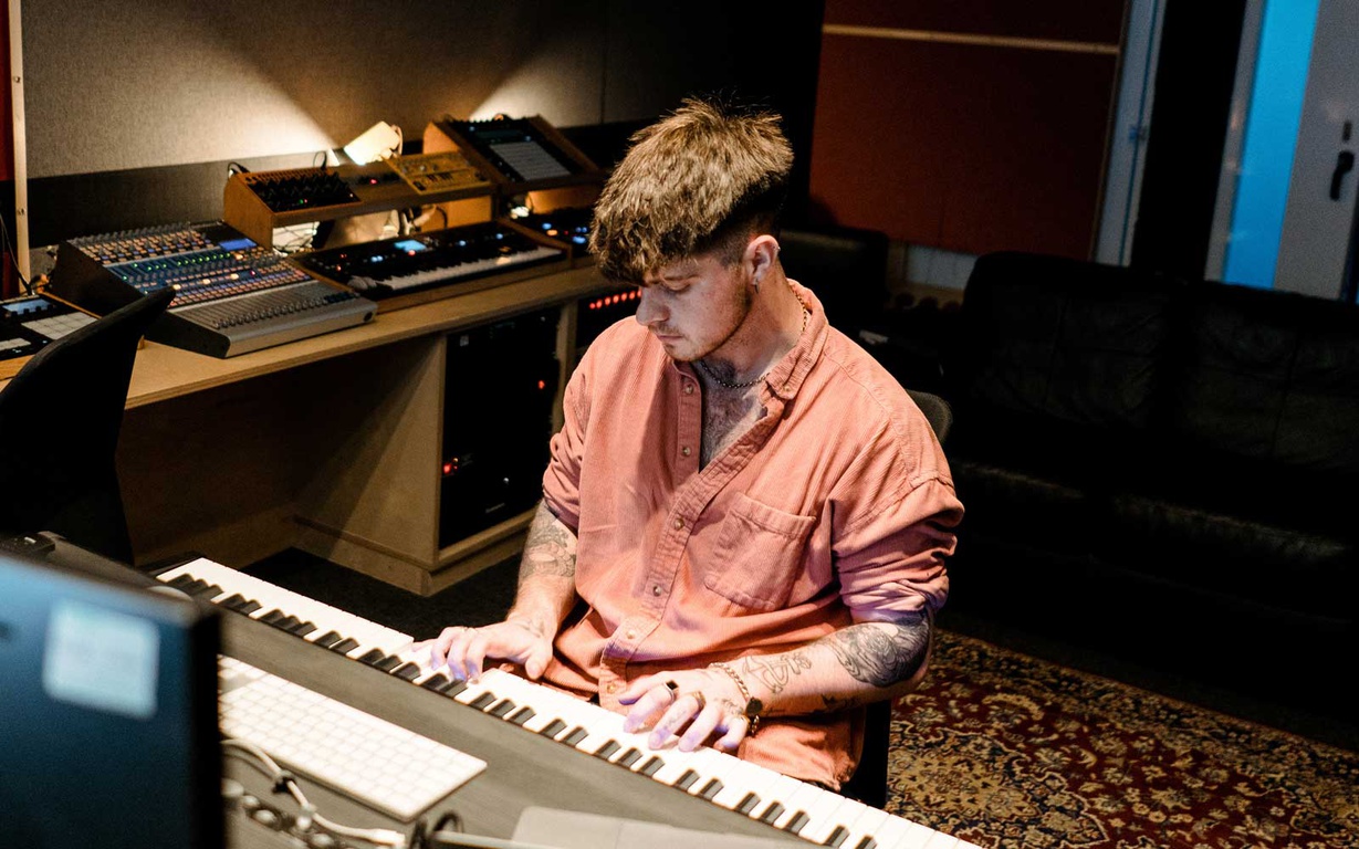 A music student recording music in a studio room. 