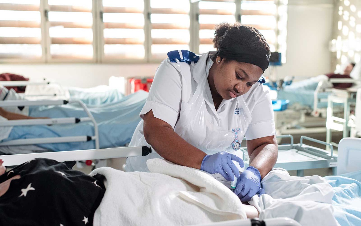 A nursing student practicing a procedure. 