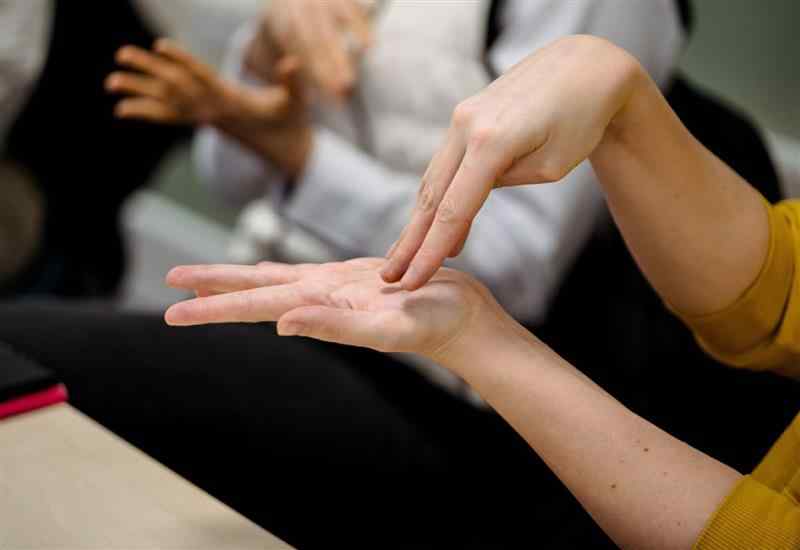 2 hands in a sign language pose with 1 hand above the other 